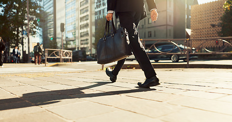 Image showing Legs, bag and business person walking, worker travel or commute to work in city with buildings. Corporate professional, sidewalk on urban street and journey to office with commuter in the morning