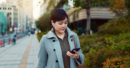 Image showing Phone, walking and business woman in the city networking on social media, mobile app or internet. Technology, street and professional Asian female person with cellphone commuting in street in town.