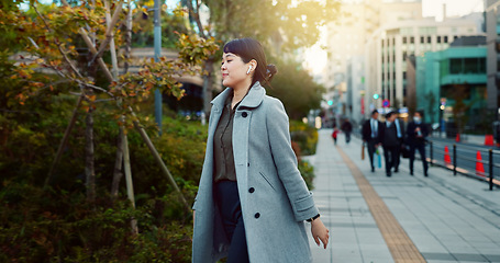 Image showing Woman, Asian and walking, travel or commute to work with professional in city with earphones. Listening to music on journey, podcast and commuter on urban street or sidewalk in Tokyo with playlist