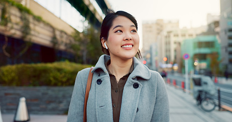Image showing Woman, Asian and walk on sidewalk, travel or commute to work with professional in city with earphones. Listening to music on journey, podcast and commuter on urban street in Tokyo with playlist