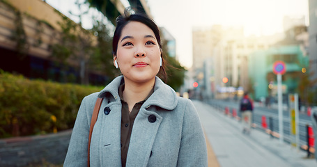 Image showing Woman, Asian and walk on sidewalk, travel or commute to work with professional in city with earphones. Listening to music on journey, podcast and commuter on urban street in Tokyo with playlist