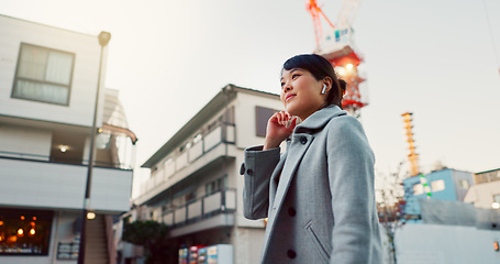 Image showing Woman, Asian and walking on sidewalk, travel or commute to work with professional in city with earphones. Listening to music on journey, podcast and commuter on urban street in Tokyo with playlist
