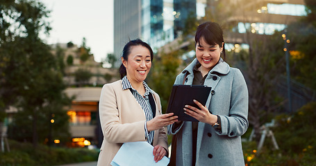 Image showing Tablet, conversation and business women in the city talking for communication or bonding. Smile, discussion and professional Asian female people speaking with digital technology together in town.