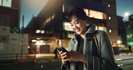 Image showing Asian woman, phone and typing in night city for communication, social media or outdoor networking. Young business female person on mobile smartphone for late evening chat or texting in an urban town
