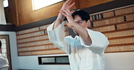 Image showing Man, martial arts and training aikido in dojo or self defence wellness, practice or combat sports. Male person, gee uniform and hands or Japanese exercise for battle challenge, fitness or fight power