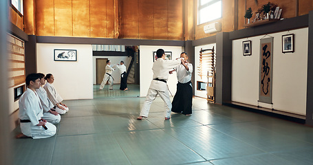 Image showing Aikido, sensei and Japanese students with training, fitness and action in class for defence or technique. Martial arts, people or fighting with discipline, uniform or confidence for culture and skill