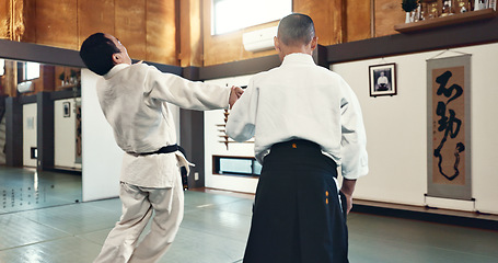 Image showing Aikido, master and fight with a sensei in martial arts with student of self defence, discipline and training. Demonstration, class or Japanese man with black belt in fighting with education of skill