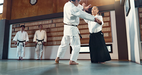Image showing Aikido, sensei and Japanese students with discipline, fitness and action in class for defence or technique. Martial arts, people or fighting with training, uniform or confidence for culture and skill