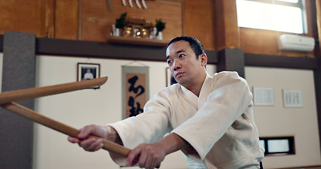 Image showing Asian man, taekwondo and training with wooden sticks for martial arts, fighting or sparring partner in dojo. People in fight practice with dummy weapon to opponent in karate for self defense at gym