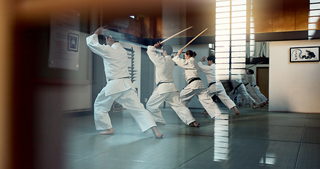 Image showing Aikido, dojo class and people training for self defense, combat and Japanese group practice sword technique. Black belt students, transparent window and learning martial arts for safety protection