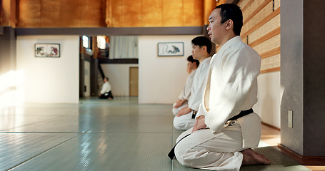 Image showing Asian man, class and bow in dojo for respect, greeting or honor to master at indoor gym. Male person or group in karate bowing on floor for etiquette, attitude or commitment in martial arts together