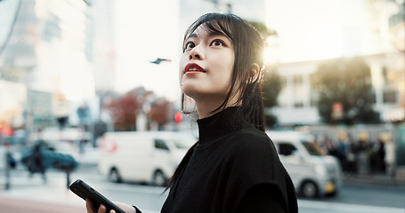 Image showing Walking, phone and Japanese woman in the city for tourist sightseeing in the street on weekend trip. Adventure, travel and young female person commuting in road of urban town in Kyoto Japan.