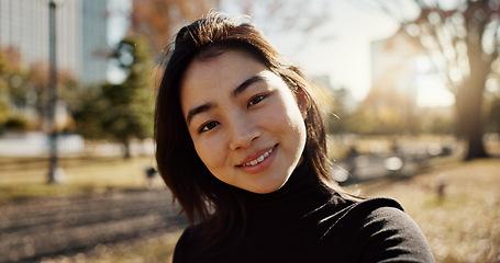 Image showing Japanese woman, smile and selfie in park, nature and path with sunshine, city and buildings with pride. Girl, person and happy in portrait by lawn, grass and trees on urban travel, outdoor and Tokyo