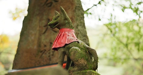 Image showing Fox statue at shrine in forest with spiritual history, Japanese culture and vintage art in nature. Travel, landmark and stone nezu jinja sculpture in woods with rock animal monument, trees and god