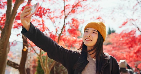 Image showing Japanese, woman and selfie in autumn nature with trees, leaves or travel to forest in Kyoto. Red, rainforest and girl smile with smartphone in fall environment with colorful woods and zen garden