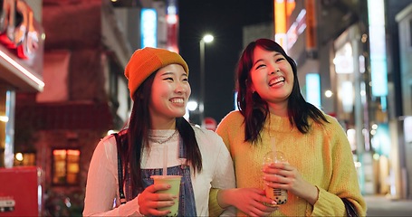 Image showing Night, travel and Japanese women in a city walking, talking and bonding with milkshake drink outdoor. Happy, female and friends in Japan with bubble tea boba, conversation and fun evening adventure