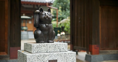 Image showing Maneki neko, statue and Japanese or traditional temple at woods garden for respect, worship or spirituality. Sculpture, lucky cat and outdoor or traveling adventure in Tokyo, Gotokuji and fortune