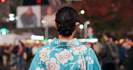 Image showing Travel, city and Japanese woman in kimono on street with crowd for culture, heritage or tradition. Back, fashion and person walking outdoor on street of urban Tokyo town for vacation or sightseeing
