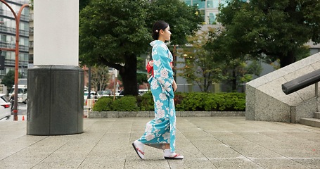 Image showing Japan, woman in a city and walking with traditional clothes, travel and fresh air with wellness, healthy and peace. Person, freedom and girl with culture, movement and thinking in a street