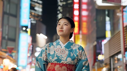 Image showing Thinking, night and Japanese woman with decision, travel and traditional clothes with wonder, relax and calm. Person, outdoor or girl in the streets, peace, commute or thoughts with culture or lights