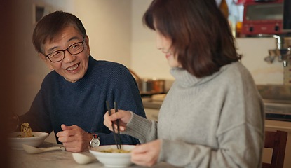 Image showing Japanese couple, food and home with conversation, love and bonding together with happiness, romance and smile. Apartment, old man or senior woman with healthy meal, nutrition and cheerful with dinner