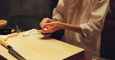 Image showing Hands, food and sushi chef in restaurant for traditional Japanese cuisine or dish closeup. Kitchen, cooking or seafood preparation and person working with fresh gourmet meal recipe ingredients