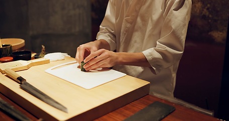 Image showing Hands, recipe and chef cooking sushi in restaurant for traditional Japanese cuisine or dish closeup. Kitchen, table for seafood preparation and person working with gourmet food or meal ingredients