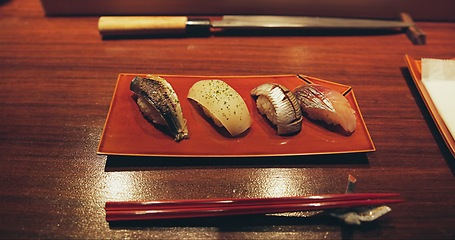 Image showing Table, restaurant and Japanese sushi for fish, raw salmon and healthy food on plate for asian culture. Japan, cuisine and rice for vitamins or nutrition, display and catering with seafood lunch menu