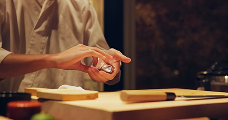 Image showing Hands, recipe and chef cooking sushi in restaurant for traditional Japanese cuisine or dish closeup. Kitchen, ingredients for seafood preparation and person working with gourmet food or meal on table