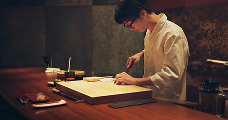 Image showing Japan chef, restaurant and cutting fish for sushi, glasses and precision with knife for healthy food in kitchen. Asian man, hands and culinary artist on job by wood board, table and raw seafood menu