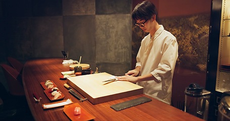 Image showing Japan chef, restaurant and knife for sushi and precision with sharp blade for gourmet fish menu in hotel. Asian man, hands and culinary artist on job by wood board, table and raw seafood on plate