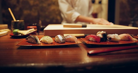 Image showing Sushi, plate and serving with chef in restaurant for luxury cuisine or raw meal preparation closeup. Kitchen, food and presentation with person cooking local Japanese seafood for service in Tokyo