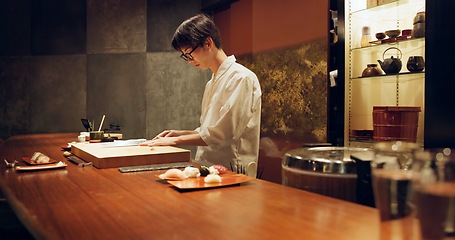 Image showing Chef, cooking and sushi in kitchen of restaurant for traditional food, cuisine or gourmet dish. Luxury, catering and salmon with Japanese man cook cutting fish for seafood meal ingredients or recipe