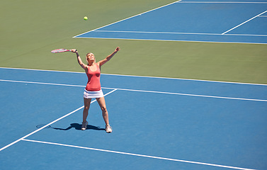 Image showing Woman, serving and game of tennis on court for sport, competition and start playing with ball and racket. Athlete, training and exercise outdoor with challenge on turf in summer match and contest