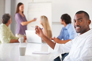 Image showing Portrait, business and black man at table in office, coworking or presentation in startup. Face, smile and creative writer at desk, entrepreneur or African professional employee with pen in meeting