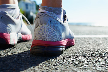 Image showing Feet, rear view and runner on street for fitness, health or cardio training in preparation or marathon. Sports, exercise and running shoes with person on asphalt for workout, performance or race