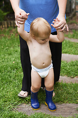 Image showing Baby, first steps and parent in outdoor, development and growth for curiosity, backyard and home. Toddler, child and face in garden, alone and childhood memories for wellness, milestone and exploring