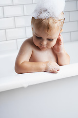 Image showing Baby in bathtub, cleaning with bubbles and soap for morning routine with health, wellness and body care. Cute toddler washing in foam with hygiene, relax and calm child thinking in water in bathroom