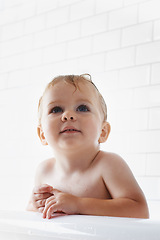 Image showing Face of toddler in bath, clean skin with mockup in morning routine for health, wellness and body care in home. Cute baby washing in water with hygiene, relax and calm child sitting in tub in bathroom