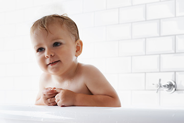 Image showing Face of baby in bathtub, clean skin and smile in morning routine for health, wellness and body care in home. Cute toddler washing in bath with hygiene, relax and calm child sitting in tub in bathroom