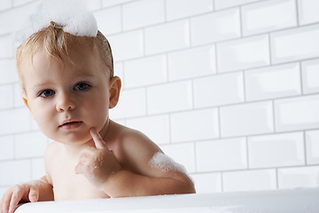 Image showing Portrait of baby in bath with soap, bubbles and cleaning on mockup in morning for hygiene, wellness or care in home. Toddler washing in foam with face, relax and face of calm child in tub in bathroom