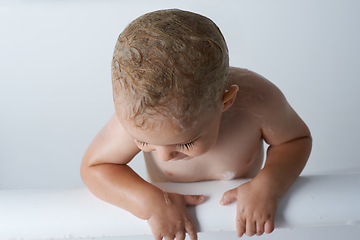 Image showing Child, baby and boy in bathtub of water for morning routine, skincare and wellness at home on white background. Wet kid cleaning with soap, foam and bubbles for washing, hygiene or mockup in bathroom