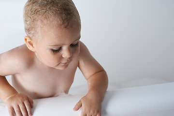 Image showing Kid, baby and boy in bathtub of water for morning routine, skincare and wellness at home in bathroom. Toddler, wet child and washing with soap, foam and bubbles for cleaning, hygiene or mockup space