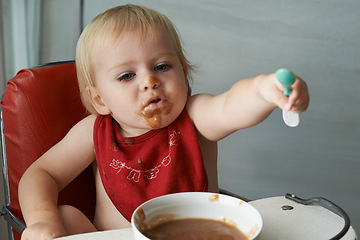 Image showing Feeding chair, eating and baby with spoon in a house for food, nutrition and fun while playing. Food, messy eater and boy kid at home with meal for child development, diet or nutrition while learning