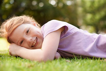 Image showing Happy, portrait and young girl on grass, relax outdoor for fun and rest in garden or backyard. Youth, free time and playing in park, field or environment with smile on face for summer vacation