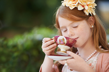Image showing Girl, child and drinking tea in garden with party for birthday, celebration and playing outdoor in home. Person, kid and porcelain cup in backyard of house with dress up, beverage and role play fun