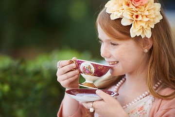 Image showing Girl, child and smile with tea in garden with party for birthday, celebration and playing outdoor in home. Person, kid and porcelain cup in backyard of house with dress up, beverage and role play fun