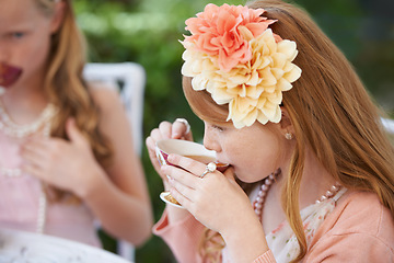 Image showing Girl, child and drinking tea in garden with party for birthday, celebration and playing outdoor in home. Person, kid and porcelain cup in backyard of house with dress up, flower and role play fun