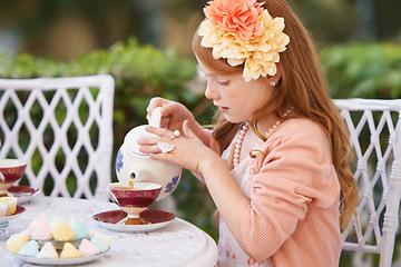 Image showing Girl, child and pouring tea in garden with party for birthday, celebration and playing outdoor in home. Person, kid and porcelain cup in backyard of house with dress up, beverage and role play fun