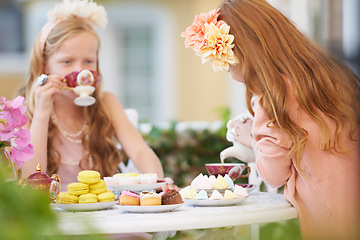 Image showing Girls, children and friends at tea party in nature for fantasy play for cake, birthday or game. Kids, food and fancy dress up or flower crown or outdoor for summer bonding, backyard or macarons